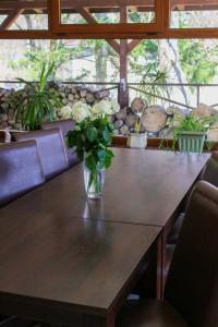 a wooden table with a vase of flowers on it at Pensjonat 4 Pory roku in Duszniki Zdrój