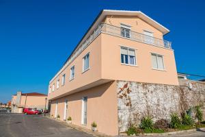 a pink building with a balcony on the side of it at Apartamento céntrico con vistas al mar in Villanueva de Arosa