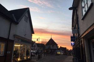 a street in a town with a sunset in the background at Quirky 3 bedroom property in Wymondham