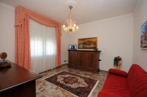 切塞納蒂科的住宿－Appartamento Del Veig，客厅配有红色沙发和吊灯