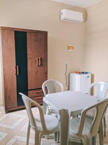 a white table and chairs in a room with a refrigerator at Hotel Flor de Lótus II in Santa Isabel do Pará
