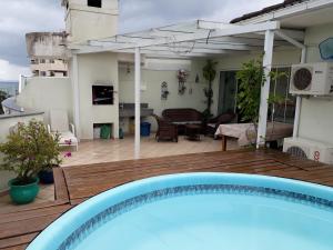 uma piscina azul num deque com um pátio em Cobertura em Canasvieiras - Vista para o Mar - 50 mtrs da Praia - Centro Canasvieiras em Florianópolis