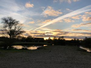 una puesta de sol sobre un cuerpo de agua con un cielo en Cit Hotel LA PYRAMIDE, en Romorantin-Lanthenay