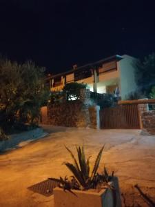 una casa di notte con una pianta davanti di Luna e Mare a Cala Gonone