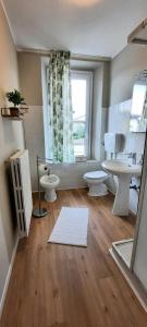 a bathroom with two toilets and a sink and a window at Appartamenti Esmera in Desenzano del Garda