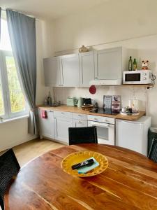 a kitchen with a wooden table and white cabinets at SLEEP INN - Arizona flat with cityview in Antwerp