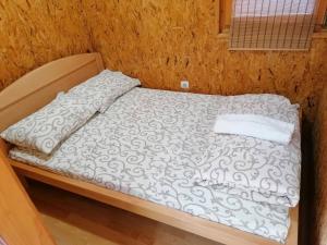 un letto con piumone bianco e cuscino sopra di VIKENDICA ODMOR NA DRINI a Ljubovija