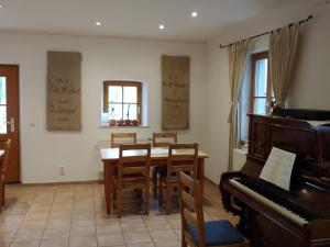 a dining room with a table and a piano at Pension Fuchsmühle in Rothenburg ob der Tauber