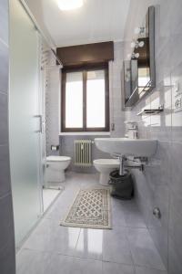 een witte badkamer met een wastafel en 2 toiletten bij Mary Rose Apartment in Vicenza