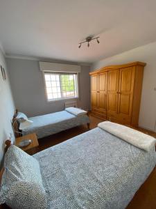 a bedroom with two beds and a window at A de Barreiro in Pontevedra