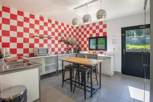 a kitchen with red and white checkered wall at Hôtel Naéco Audierne in Audierne