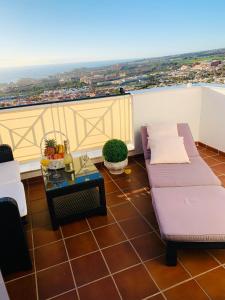 a balcony with a couch and a table with a view at Duplex Penthouse Panoramic Del Atlantico in Adeje