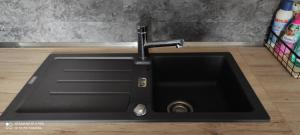a black kitchen sink with a faucet at Ferienhaus im Ederbergland in Hatzfeld