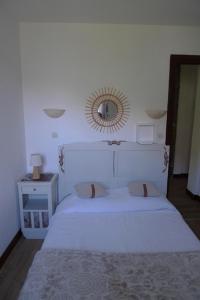 Résidence Perce Neige في لوز سانت سوفير: غرفة نوم مع سرير أبيض ومرآة على الحائط