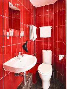 bagno rosso con servizi igienici e lavandino di Hotel Lemon a Mentone