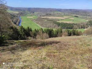 a view of a grassy hill with a river at Ferienhaus im Ederbergland in Hatzfeld