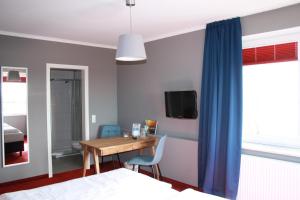 sypialnia z biurkiem oraz pokój z 2 łóżkami w obiekcie Gasthof Großer Krug w mieście Norddeich