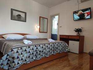 LukaにあるPansion Alen - Dugi otokのベッドルーム1室(ベッド1台、タオル2枚付)