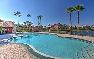 a swimming pool at a resort with palm trees at Disney Adjacent in Kissimmee