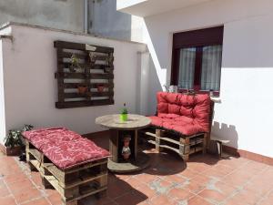 a patio with a table and a red chair and a table at Pauliva in Arévalo