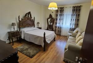 a bedroom with a large bed and a couch at Apartamento Mondego in Penacova