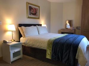 a bedroom with a bed and a night stand with a phone at Balreask Bar, Restaurant & Guest Accommodation in Navan