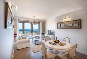 een woonkamer met een tafel en stoelen en uitzicht op de oceaan bij Allium Bodrum Resort & Spa in Yalıkavak
