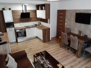 eine Küche und ein Wohnzimmer mit einem Tisch und einem Sofa in der Unterkunft Apartmán pod hradem in Znojmo