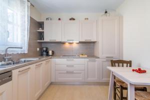 a kitchen with white cabinets and a sink and a table at Villa Blue Sky in Tripití