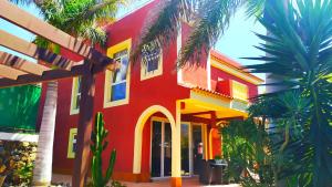 una casa colorata con palme di fronte di Casa Viera a Buzanada