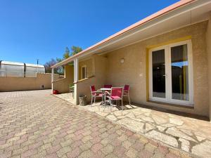een terras met een tafel en stoelen buiten een huis bij Hotel Myriam Vias Plage in Vias