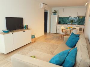 ein Wohnzimmer mit einem weißen Sofa und einem TV in der Unterkunft Nett Apartman in Siófok