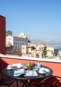 a table on a balcony with a view of a city at Dimora del Leone Gaeta in Gaeta