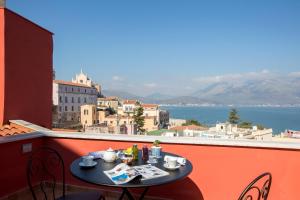 a table on a balcony with a view of the water at Dimora del Leone Gaeta in Gaeta