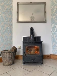 a fireplace in a living room with a mirror at Ard Na Mara Self Catering Isle of Mull in Dervaig