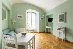 a living room with green walls and a white table at Liberty Colosseo in Rome