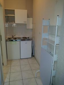 eine kleine Küche mit weißen Schränken und einem Waschbecken in der Unterkunft Apartment Antik in Wetzlar