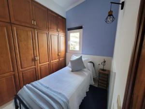 a blue bedroom with a bed and wooden cabinets at Sitio la era in Fuencaliente de la Palma