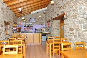 un restaurante con mesas y sillas de madera y una barra en Albergue El Aleman en Boente