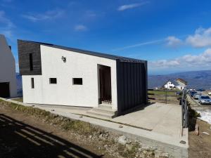 ein kleines weißes Gebäude mit schwarzem Dach in der Unterkunft ESCAPE in Petroşani