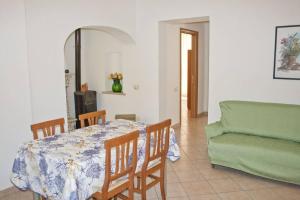 a dining room with a table and a green couch at La casa di Matilde in Rodi Garganico