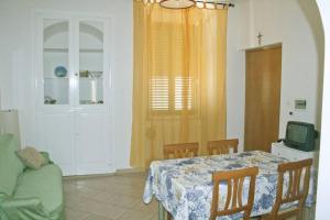 a dining room with a table and a green couch at La casa di Matilde in Rodi Garganico