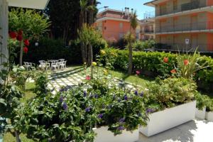 un giardino di fronte a un edificio fiorito di Hotel President a San Benedetto del Tronto