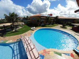 una gran piscina con sillas y una casa en Foz do Sauipe Eco Hotel, en Porto de Sauipe