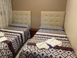 una camera con due letti con cuscini sopra di Apartamentos Gala a Noja