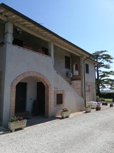 a white building with an archway and potted plants at B&B Il Cascinale in Bettona