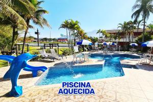 un complejo con 2 piscinas con un tobogán de agua en Hotel Pousada Vivendas do Sol e Mar, en Caraguatatuba