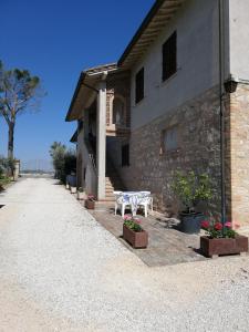 a stone building with a table and flowers in front of it at B&B Il Cascinale in Bettona