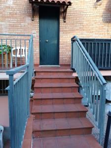 un conjunto de escaleras que conducen a una puerta verde en "La Gardenia" Affittacamere, en Marina di Montemarciano
