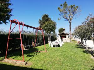 a swing set in a yard with a table at B&B Il Cascinale in Bettona